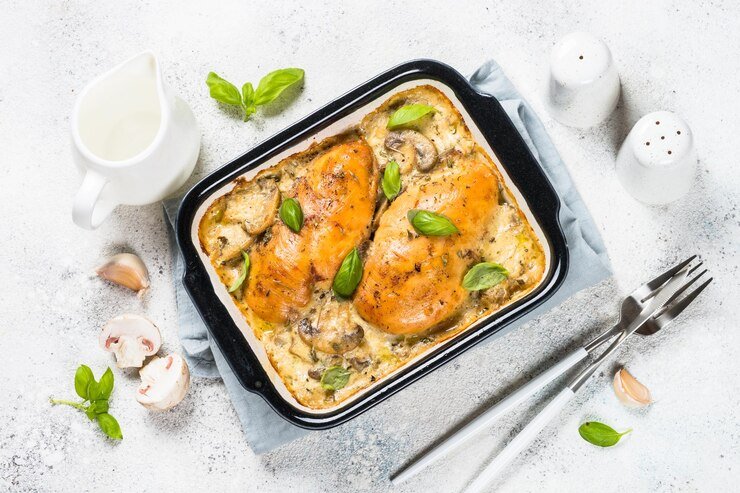 Baked creamy chicken and asparagus casserole with golden cheese topping in a white dish